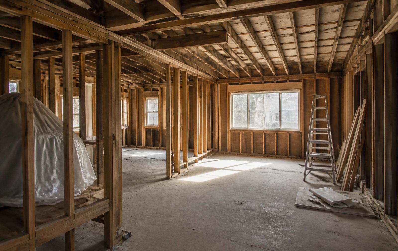 A property interior mid-renovation, studs exposed before finishes go in